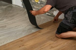 worker installing vinyl flooring