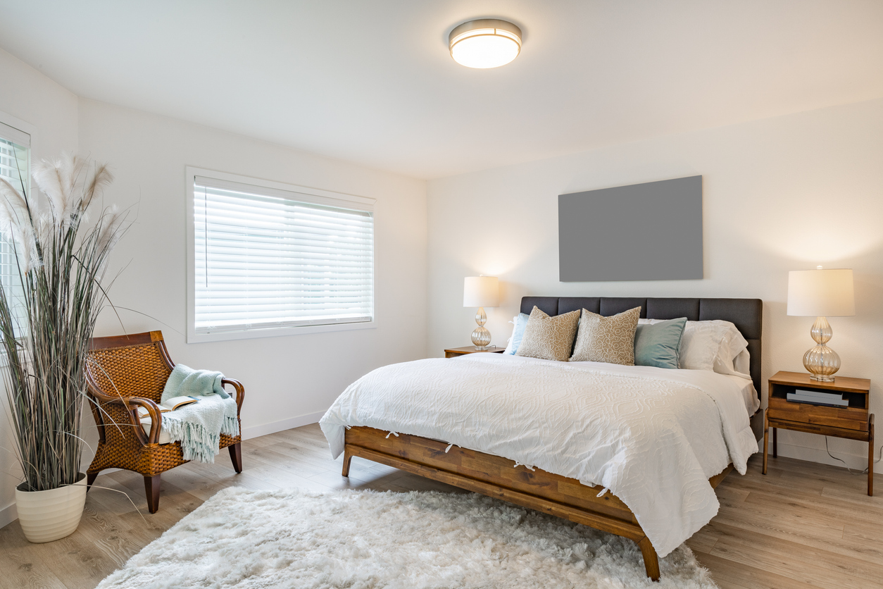 a modern bedroom with light brown laminate flooring