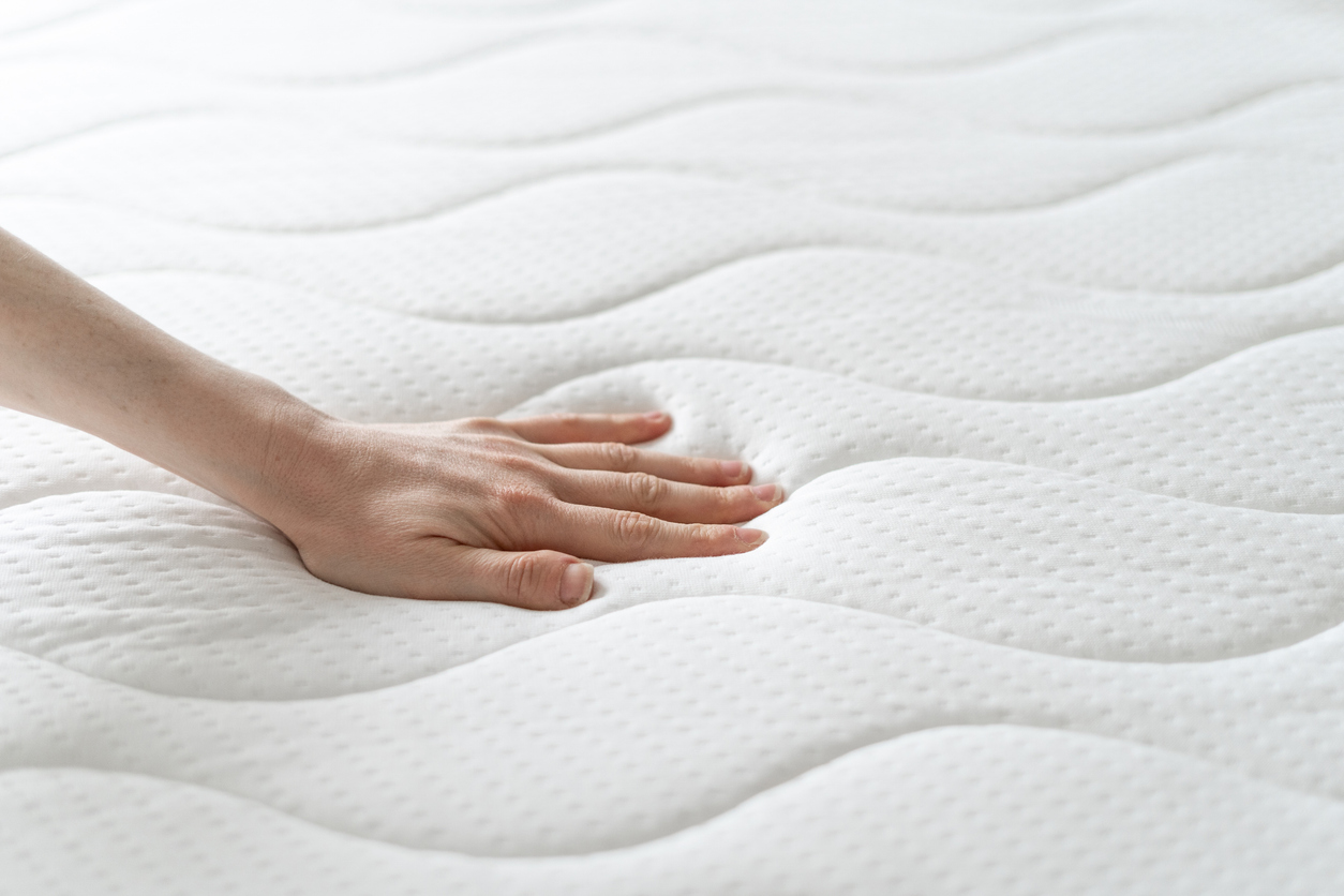 a person pressing down on a memory foam mattress